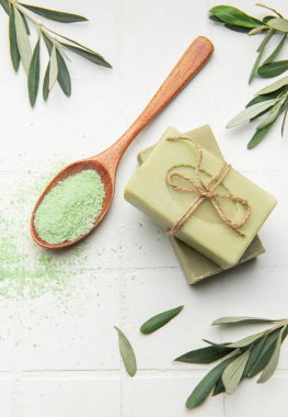 Doğal zeytin sabunu, banyo tuzu ve zeytin ağacı yapraklı spa kompozisyonu cilt bakımını ve rahatlamasını teşvik eder.