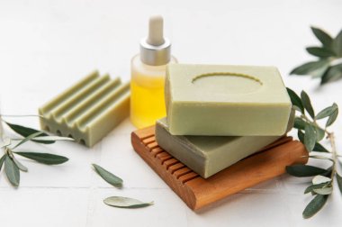 Doğal zeytin sabunları ahşap bir sabun kabının üzerinde otururlar, yanında da bir şişe gerekli yağ ve taze zeytin dalları, atmosfer gibi bir spa 'yı desteklerler.