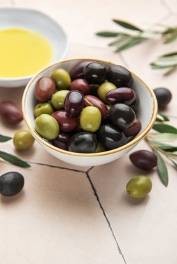 Renkli zeytinler, zeytinyağı ve zeytin dalları Akdeniz mutfağı sahnesi oluşturur