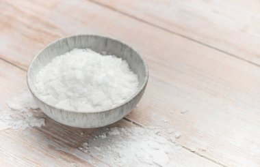 Magnezyum klorür taneleri bir kasede sunuluyor, dokularını ve potansiyel kullanımlarını sağlık, güzellik ve endüstriyel uygulamalarda sergiliyorlar.