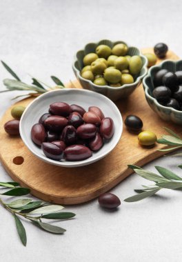 Tahtaya dizilmiş çeşitli zeytinler canlı ve iştah açıcı bir görüntü oluşturuyor.
