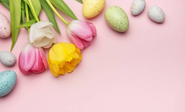 Paskalya yumurtası ve laleleri pembe arka planda düzenlenmiş. Kopya alanı ile canlı bir bahar sınırı oluşturuyor.
