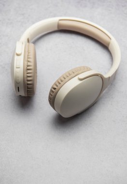 Gri mermer bir yüzey üzerinde dinlenen şık kulaklıklar, minimalist bir tasarım sergiliyor.