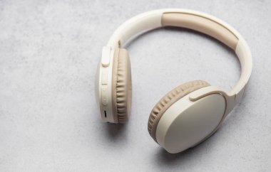 Gri mermer bir yüzey üzerinde dinlenen şık kulaklıklar, minimalist bir tasarım sergiliyor.