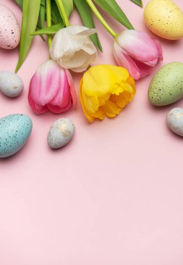 Paskalya yumurtası ve laleleri pembe arka planda düzenlenmiş. Kopya alanı ile canlı bir bahar sınırı oluşturuyor.