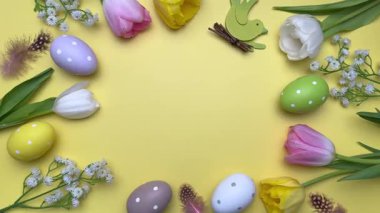 Paskalya yumurtaları ve laleler renkli bir çerçeve oluşturuyor.