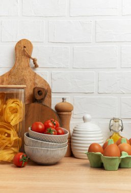 Mutfak tezgahında makarna, domates, yumurta ve zeytinyağı gibi lezzetli İtalyan yemekleri sergilenerek sıcak ve davetkar bir atmosfer yaratılıyor.