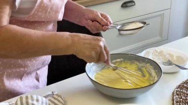 Hamur işi şefi unu kasede hamura çeviriyor.