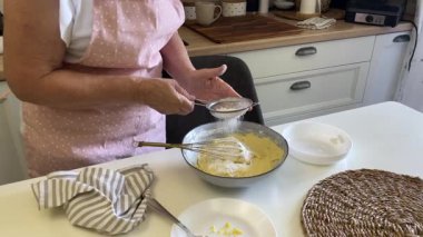 Hamur işi şefi unu kasede hamura çeviriyor.