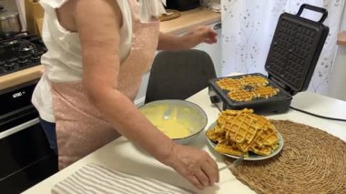 Şef waffle ızgarasından taze waffle yapıyor.