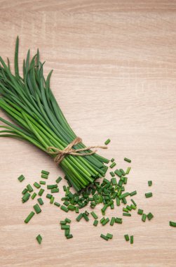 Ahşap bir masaya saçılmış sicimle bağlanmış, aşçılık için hazır taze kesilmiş soğanlar.