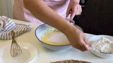 Hamur işi şefi unu kasede hamura çeviriyor.