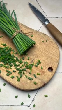 Taze soğanlar ahşap bir masada doğranır.