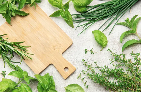 Mutfak masasında uzanan taze otlar ve boş ahşap kesme tahtaları.
