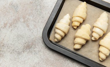 Fırında pişmemiş kruvasanlar, fırında pişirilmeye hazır.