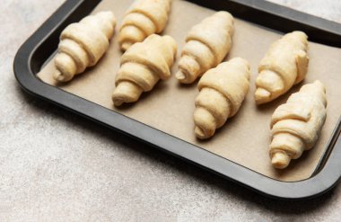 Fırında pişmemiş kruvasanlar, fırında pişirilmeye hazır.