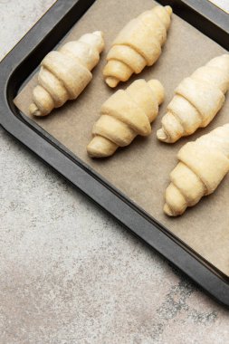 Fırında pişmemiş kruvasanlar, fırında pişirilmeye hazır.