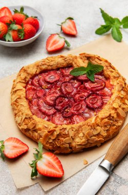 Badem gevreği ve nane yapraklarıyla süslenmiş taze pişmiş çilek galeti.