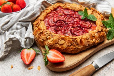 Badem gevreği ve nane yapraklarıyla süslenmiş taze pişmiş çilek galeti.