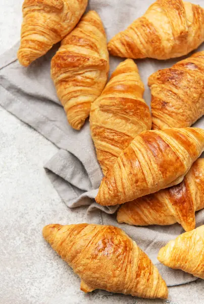 Altın sarısı kruvasanlar gri bir peçeteye dizilmiş lezzetli Fransız hamur işleri sergiliyorlar.