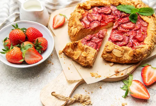 Badem gevreği ve nane yapraklarıyla süslenmiş taze pişmiş çilek galeti.