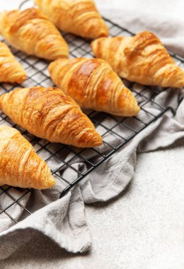 Altın sarısı kruvasanlar tel askıda dinleniyor, baştan çıkarıcı bir kahvaltı sahnesi yaratıyor.