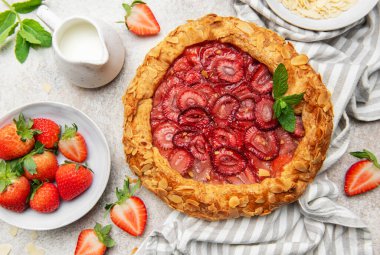 Badem gevreği ve nane yapraklı taze fırınlanmış çilek galeti taze çilek ve sütle servis edilir. Yaz tatlısı için mükemmel.