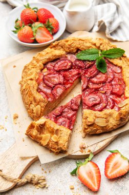 Badem gevreği ve nane yapraklarıyla süslenmiş taze pişmiş çilek galeti.