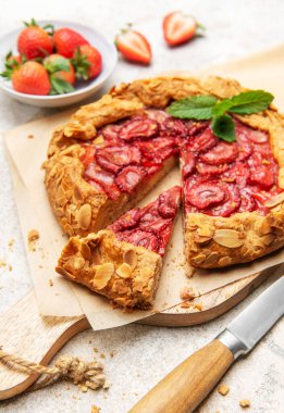 Badem gevreği ve nane yapraklarıyla süslenmiş taze pişmiş çilek galeti.