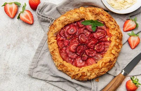 Badem gevreği ve nane yapraklarıyla süslenmiş taze pişmiş çilek galeti.