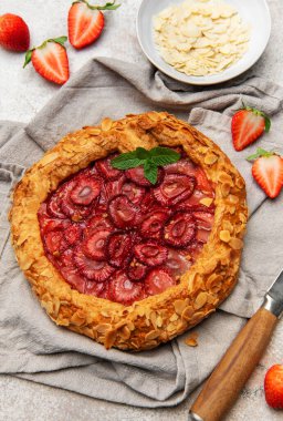 Badem gevreği ve nane yapraklarıyla süslenmiş taze pişmiş çilek galeti.