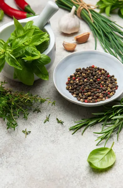 Aromatik otlar, baharatlar ve dokulu bir yüzeye dizilmiş renkli kırmızı biberler aşçılık ürünlerini geliştirmeye hazırdır.