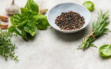 Aromatik otlar, baharatlar ve dokulu bir yüzeye dizilmiş renkli kırmızı biberler aşçılık ürünlerini geliştirmeye hazırdır.