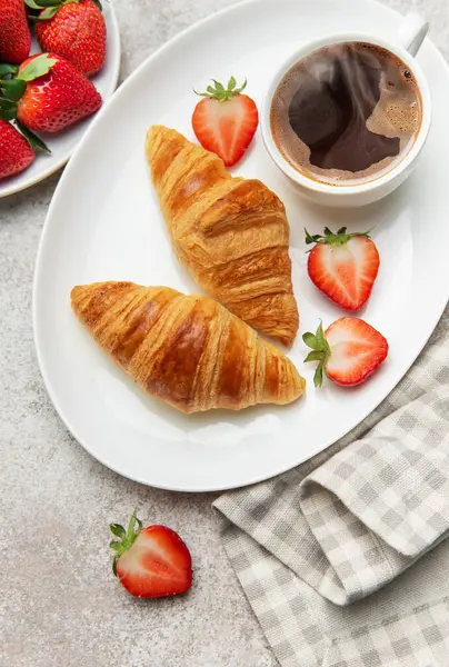 Taze kruvasan, olgun çilek ve dumanı tüten bir fincan kahvenin tadını çıkarıyorum.