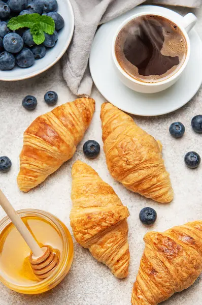 Kahvaltıda taze kruvasan, yabanmersini, bal ve bir fincan sade kahveyle servis edilir.