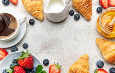 Taze pişmiş kruvasan, buharda pişmiş kahve, canlı böğürtlen ve altın bal içeren nefis kıtasal kahvaltı seti cazip bir sabah ziyafeti yaratıyor.