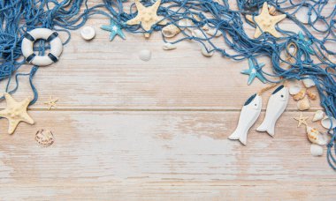 Deniz kabukları, deniz yıldızları ve ahşap balıklarla dekoratif balık ağı kırsal beyaz ahşap arka planda bir çerçeve oluşturuyor.