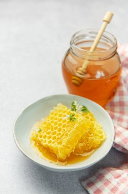 Altın bal, bal peteği ve arı poleni hafif bir arkaplanda lezzetli ve sağlıklı bir kompozisyon oluşturuyor.