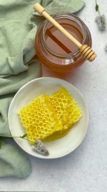 Ballı bal peteği parçaları yeşil masa örtülü beyaz bir masada.