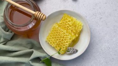 Ballı bal peteği parçaları yeşil masa örtülü beyaz bir masada.