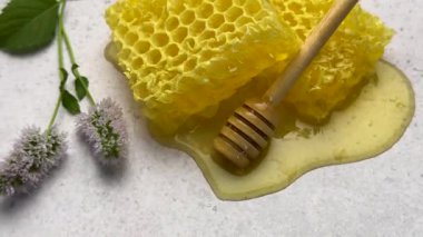 Beyaz arka planda naneli bal petekleri ve bal çubuğu