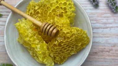 Taze bal peteği ve bal kabı ahşap bir masada üzerinde nane filizleriyle.