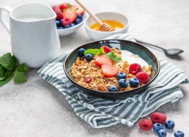 Granola ve taze meyve sağlıklı bir kahvaltı veya dokulu bir arka planda atıştırmalık hazırlar.