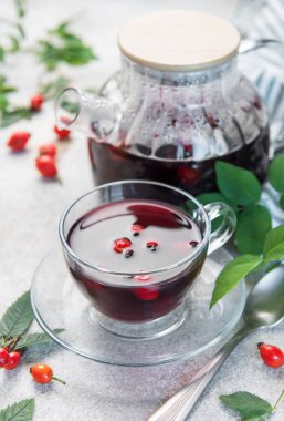 Cam çaydanlıkta demlenen buğulanmış gül çayı ve cam bardakta servis edilen sıcaklık ve sağlık.