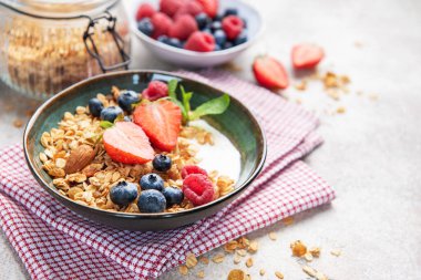 Kahvaltıya taze çilek, yabanmersini, ahududu ve badem ile hazırlanmış tahıl gevreği.