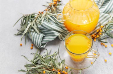 Deniz dikenli sıcak bitkisel çay demlikten cam bir fincana dökülüyor.