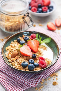 Kahvaltıya taze çilek, yabanmersini, ahududu ve badem ile hazırlanmış tahıl gevreği.