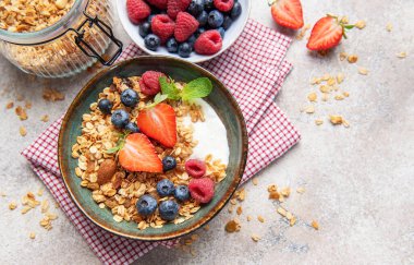 Kahvaltıya taze çilek, yabanmersini, ahududu ve badem ile hazırlanmış tahıl gevreği.