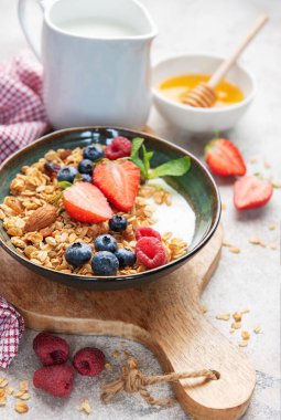 Granola with yogurt, strawberries, blueberries, raspberries, and almonds for a healthy start