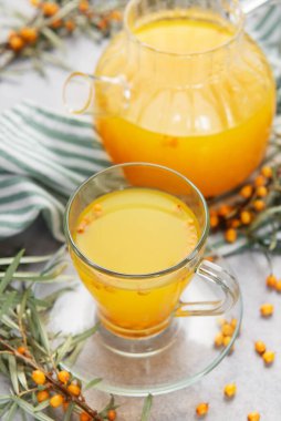 Deniz dikenli sıcak bitkisel çay demlikten cam bir fincana dökülüyor.